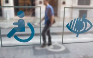 Pictogrammes du handicap moteur et visuel collés sur la vitrine d'une maison départementale des personnes handicapées