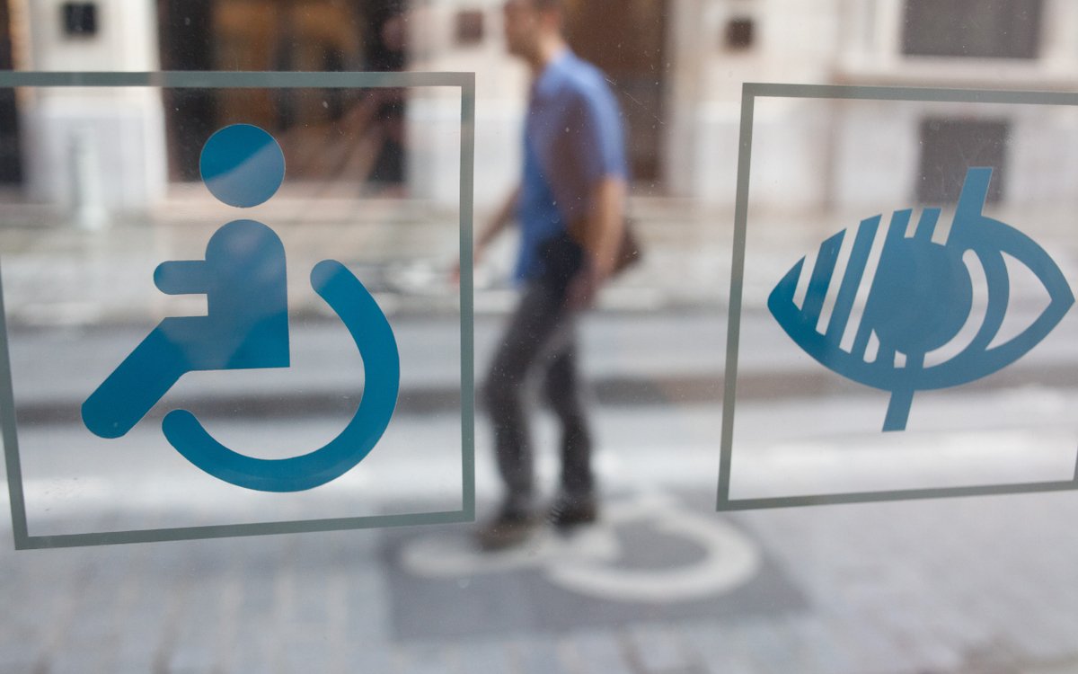 Pictogrammes du handicap moteur et visuel collés sur la vitrine d'une maison départementale des personnes handicapées