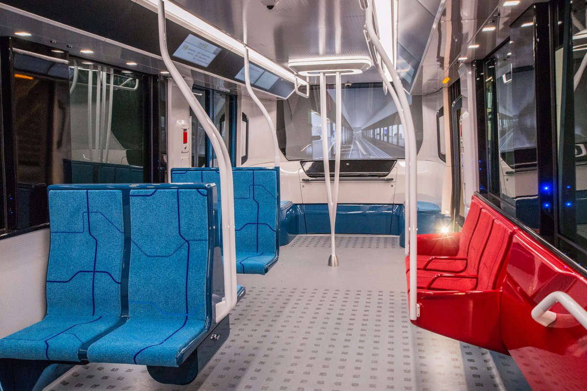 Sièges bleus et rouges à l'intérieur d'une rame de métro neuve du Grand Paris Express